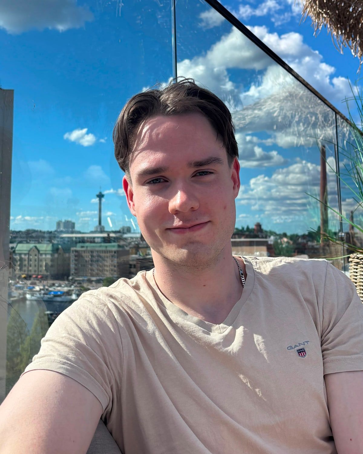 Magnus Forsblom smiling on a rooftop terrace, with the Tampere skyline behind him